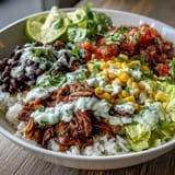 Carnitas Burrito Bowl with tender shredded pork, fluffy rice, and colorful toppings, ready to serve.