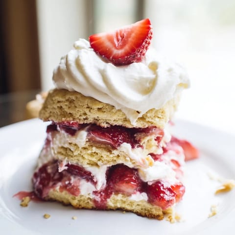 Freshly baked Strawberry Shortcake biscuits with juicy sliced strawberries and clouds of whipped cream.