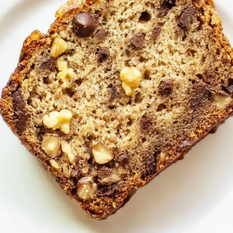 Freshly baked banana bread cooling on a wire rack, showcasing a moist, golden-brown crust.