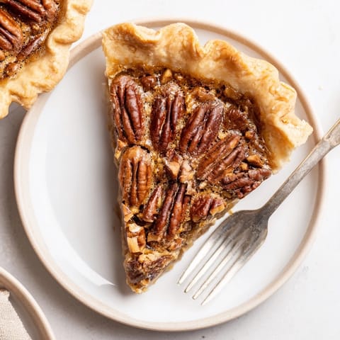 Freshly baked Southern pecan pie with a golden flaky crust and gooey brown sugar filling, loaded with toasted pecans.
