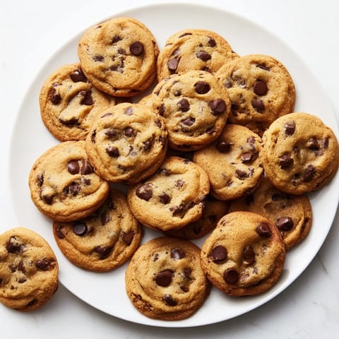 Golden-brown Chocolate Chip Cookies with melty semi-sweet chocolate chips on a cooling rack.