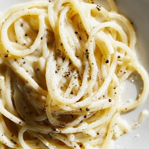 Spaghetti Cacio e Pepe twirled on a fork, showing the velvety, peppery sauce perfect for a quick Italian dinner.