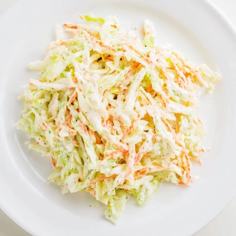 Vibrant bowl of Coleslaw with shredded cabbage, carrots, and onion, ready to complement any picnic spread.