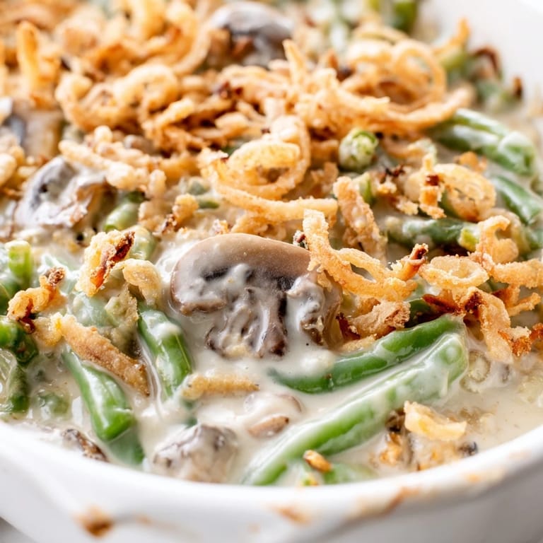 Bubbling green bean casserole hot from the oven, topped with crunchy fried onions and steam rising.