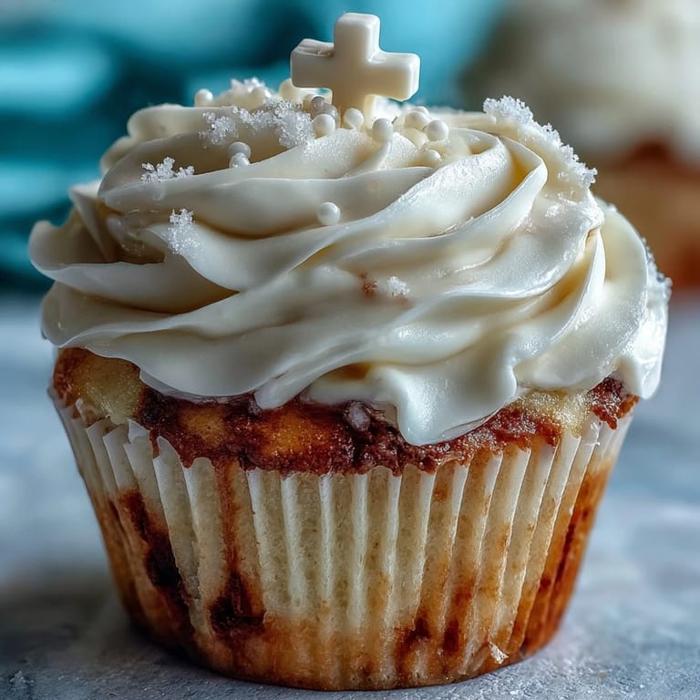 Tender vanilla cupcakes topped with creamy buttercream and handcrafted white fondant cross toppers for a sacred celebration.