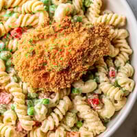 Tender pasta and golden crispy chicken bites tossed with sweet peas in a creamy ranch dressing, served chilled.