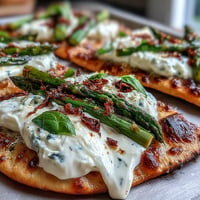 Roasted asparagus flatbread with burrata and lemon, topped with fresh basil and chili flakes for a vibrant spring appetizer.  