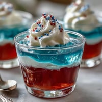 Vibrant red, white, and blue layers in 4th of July Firecracker Jello Shots.